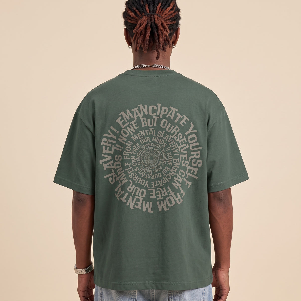 Blackness Emancipation Tee Cactus Green — close-up of the spiral Emancipate Yourself typography back print worn on the back, oversized heavyweight cotton streetwear tee by We Are Blackness