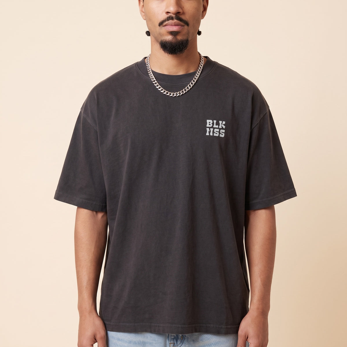 Blackness WABLKNSS Tee Black — close-up of the BLK NSS chest logo and ribbed collar, oversized heavyweight cotton streetwear tee by We Are Blackness