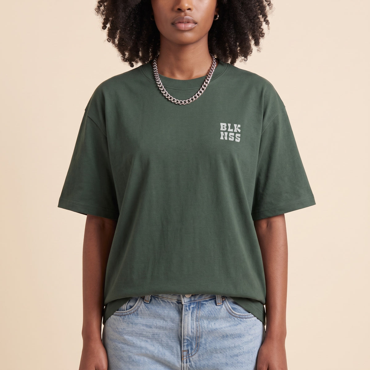 Blackness WABLKNSS Tee Green — close-up of the BLK NSS chest logo and ribbed collar, oversized heavyweight cotton streetwear tee by We Are Blackness