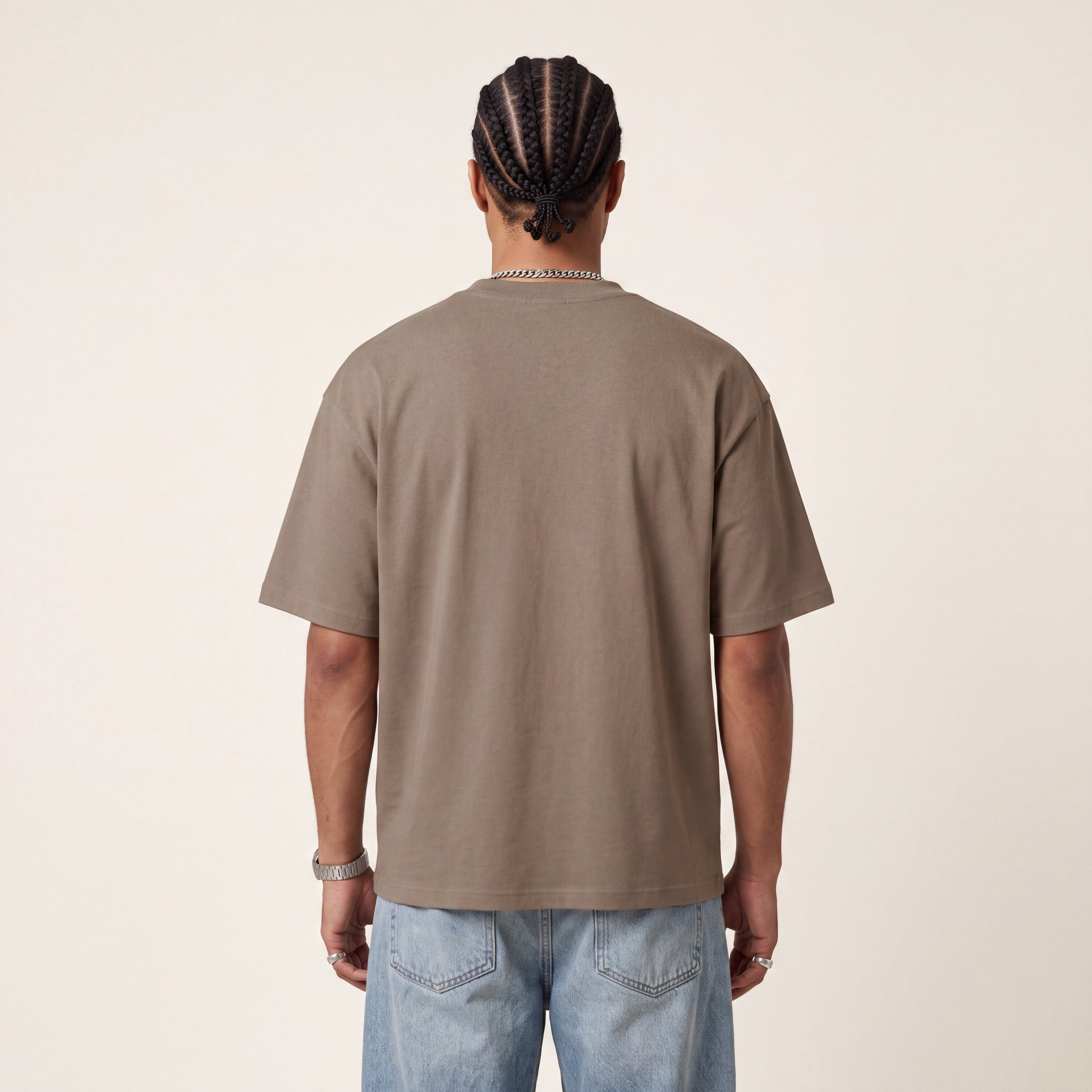 Wear Blackness Tee Brown worn by model, back view showing the clean plain back on warm ivory studio backdrop