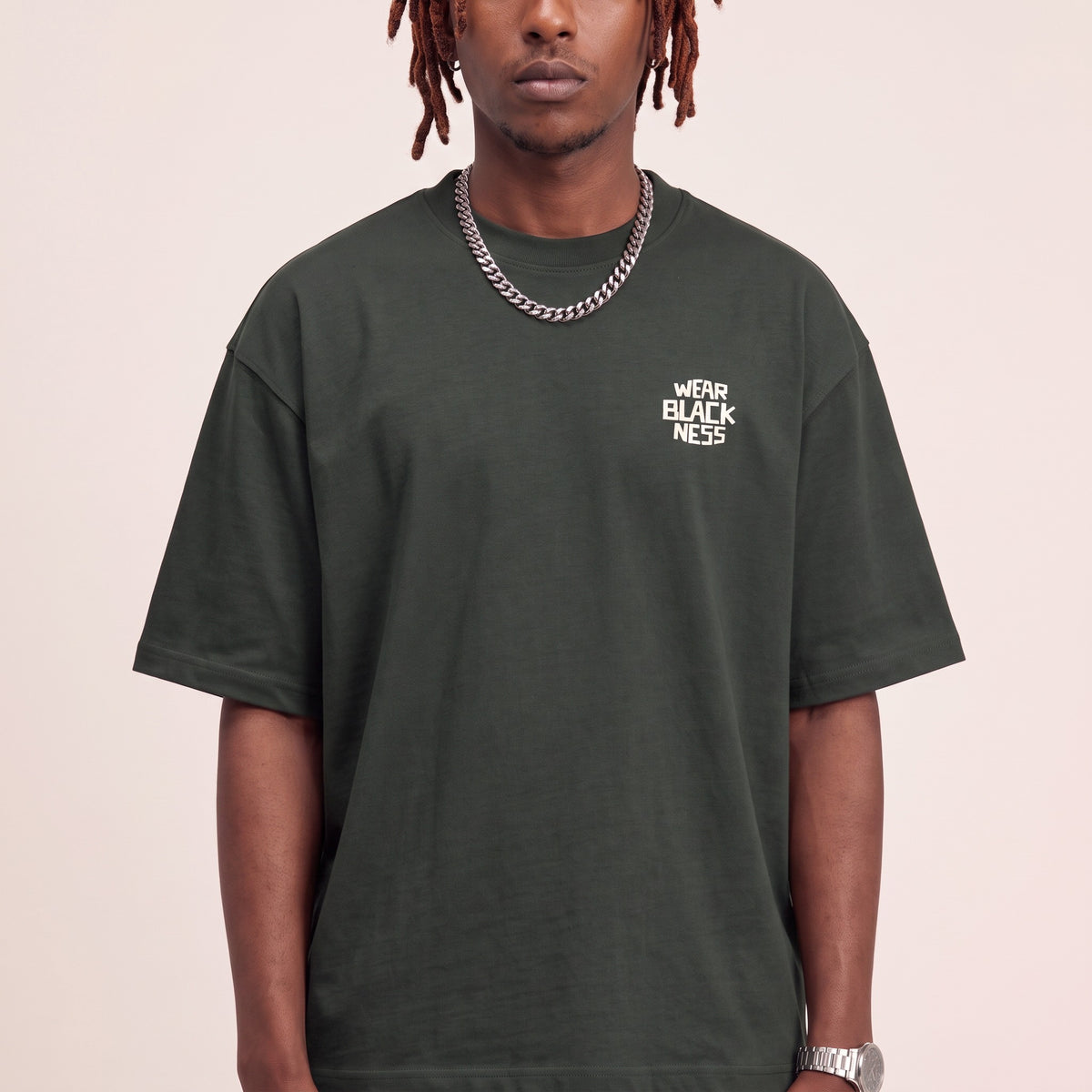 Wear Blackness Tee Green — close-up of the Wear Blackness chest logo and ribbed collar, oversized heavyweight cotton streetwear tee by We Are Blackness