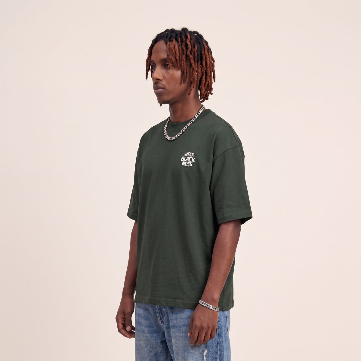 Wear Blackness Tee Green — side view of the drop-shoulder sleeve and boxy oversized fit, oversized heavyweight cotton streetwear tee by We Are Blackness