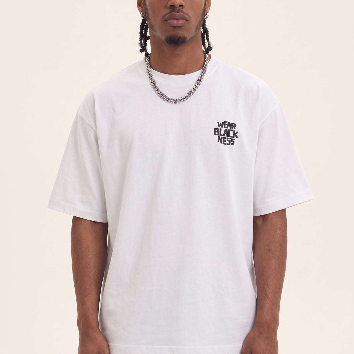 Wear Blackness Tee White — close-up of the Wear Blackness chest logo and ribbed collar, oversized heavyweight cotton streetwear tee by We Are Blackness